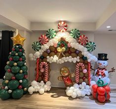 an inflatable gingerbread house decorated for christmas with balloons and candy canes