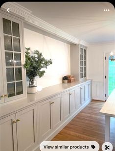 an empty kitchen with white cabinets and wood flooring is seen on the phone screen