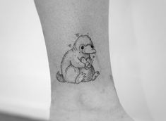 a black and white photo of a small tattoo on the leg of a person's foot