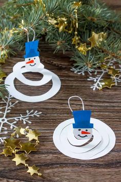 paper snowman ornament hanging from a christmas tree