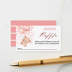 a baby shower diaper raffle card next to a pen