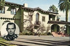 an old photo of a man in front of a house with palm trees and stairs