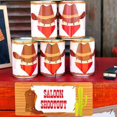 four tins with cowboy hats on them are sitting on a table next to a phone