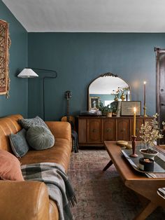 a living room filled with furniture and a large mirror on the wall above it's fireplace