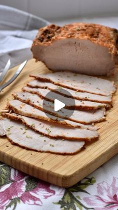 sliced meat sitting on top of a wooden cutting board