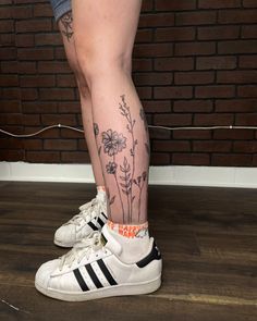 a woman's legs with flowers on them