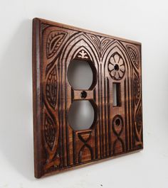 an old wooden switch plate with intricate designs on it