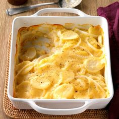 a casserole dish with potatoes and gravy in it on a table