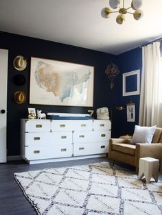 an image of a baby nursery room with blue walls and white furniture in the corner