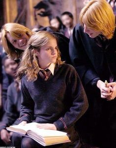 a group of young people standing next to each other in front of a man holding a book