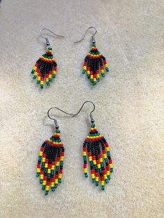 three pairs of beaded earrings sitting on the floor