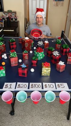 a man sitting at a table with many presents on it