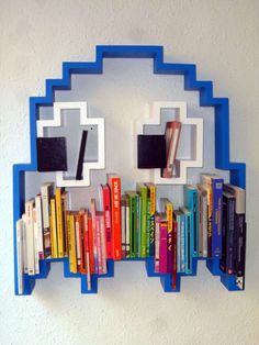 a blue book shelf with books on it and a clock made out of the top