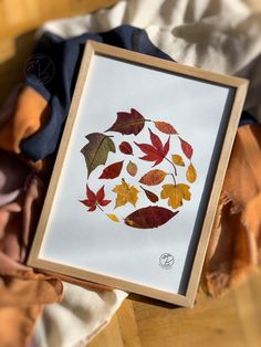 a painting with leaves on it is sitting on a table next to a stuffed animal