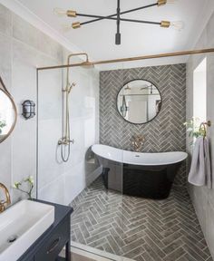 a bathroom with a black and white bathtub next to a large mirror on the wall