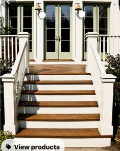 a white house with two doors and steps leading up to the front door