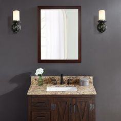 a bathroom vanity with a mirror above it and two lights on the wall next to it