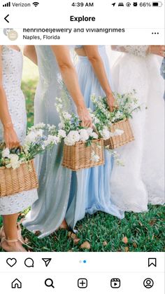 three bridesmaids are holding baskets with flowers in them and one is wearing a blue dress