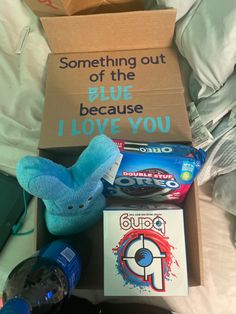 an open box with toothpaste and other items in it sitting on a bed