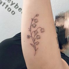 a woman's arm with a flower tattoo on the left side of her arm