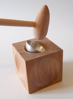 a wooden block with a metal spoon in it