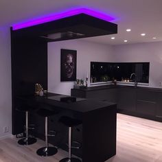 a modern kitchen with black counter tops and bar stools