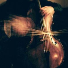 a blurry photo of a violin with its strings still attached to the back of it