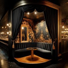 a room with black curtains and a round table in the center surrounded by velvet couches