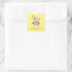 a white paper bag with a yellow sticker on the front that says happy birthday