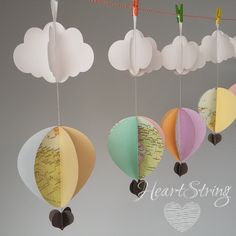 three paper hot air balloons hanging from strings