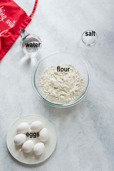 flour, eggs and water in bowls on a table