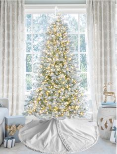 a white christmas tree in front of a window