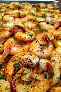 a pan filled with shrimp and vegetables covered in seasoning