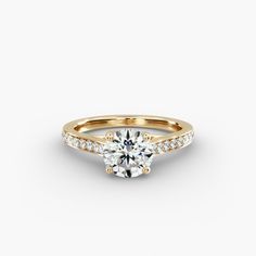 a yellow gold engagement ring with an oval cut diamond in the center and side stones