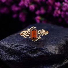 an orange stone ring sitting on top of a rock