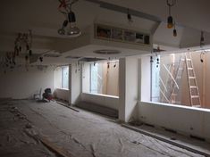 an unfinished room with several windows and ladders hanging from the ceiling in front of them