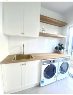 a washer and dryer sitting in a kitchen next to each other on top of cabinets