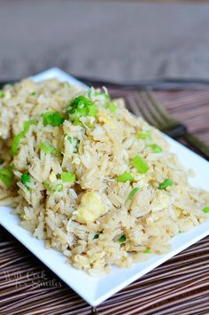 a white plate topped with rice and green onions