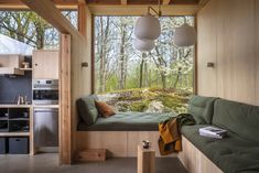 a living room filled with furniture next to a window covered in forest scenes and trees