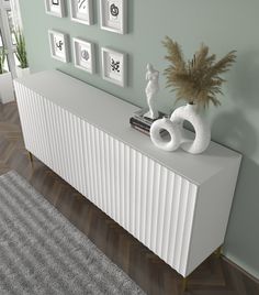 a white radiator sitting on top of a wooden floor next to a plant