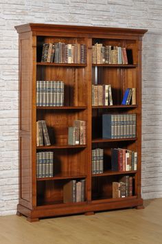 a wooden bookcase filled with lots of books on top of a hard wood floor