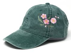 a green baseball cap with pink flowers embroidered on the front and side, against a white background