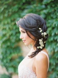 a woman in a wedding dress with flowers in her hair