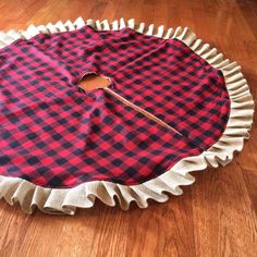 a red and black checkered cloth with a pair of scissors in it on the floor