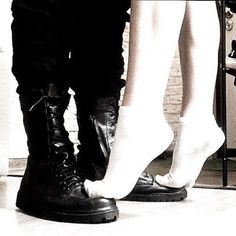 two people standing next to each other wearing boots