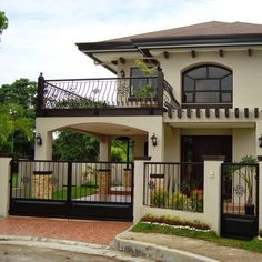 a white house with black iron fence and balcony