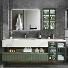 a bathroom with marble counter tops and green accents on the sink, along with white towels