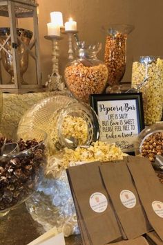 a table topped with lots of different types of snacks and candy bar bags filled with popcorn