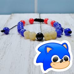 an image of a bracelet made out of glass beads and plastic beads with a cartoon character on it