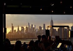 a group of people sitting at a table in front of a city skyline